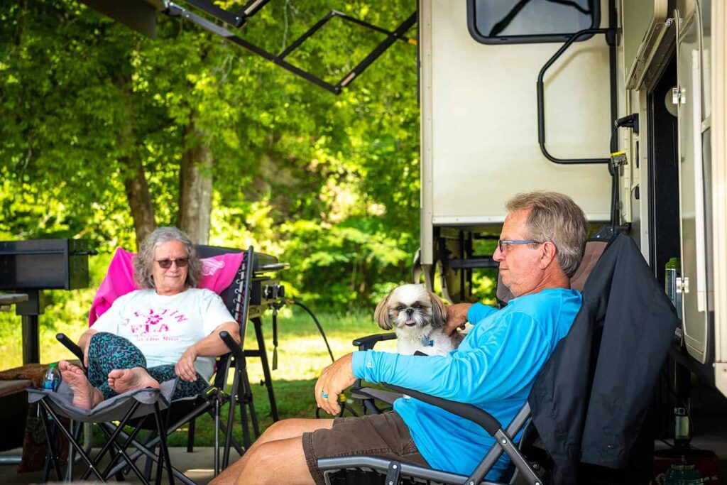 A couple and their dog relax at Pigeon Forge Landing RV Resort